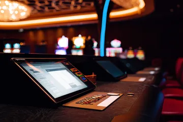 A man celebrating a winning moment on his laptop while gaming symbols float around him, capturing the excitement of ZS777 games.